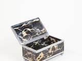 a black and gold marbled box on a white surface