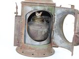 an old rusty lantern with a cat sitting inside of it