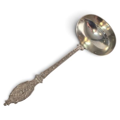 a silver spoon with a handle on a white surface