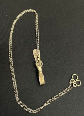 a close up of a necklace with a key on a black surface