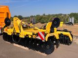 un gros tracteur jaune garé sur le bord de la route