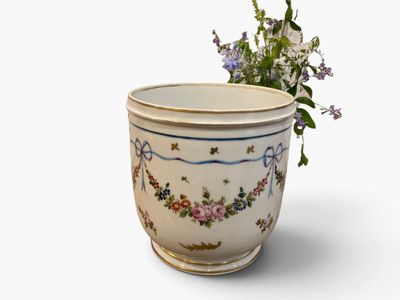 a vase with flowers in it on a white surface