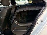 a white car with its door open and a black seat in the back