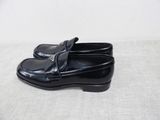 pair of black loafers on a white surface with a white background