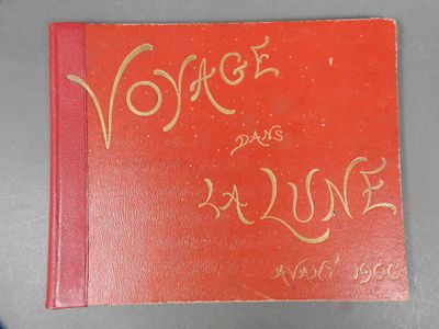 an old red book with gold writing on it sitting on top of a table
