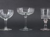 three empty wine glasses are lined up on a black surface