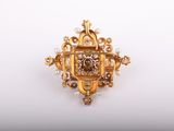 a close up of a gold broochle with pearls on it