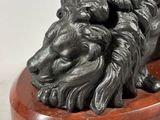 an image of a statue of a lion on a wooden base