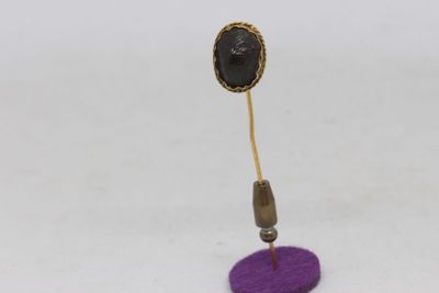 gold plated earring with a purple base and a black stone