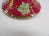 a red vase with gold and green designs on it