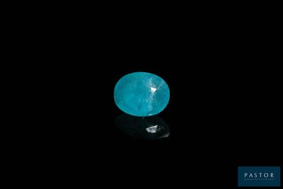 a close up of a blue diamond on a black surface
