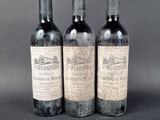 three bottles of wine sitting on top of a table next to each other