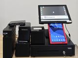 une tablette posée sur une caisse enregistreuse