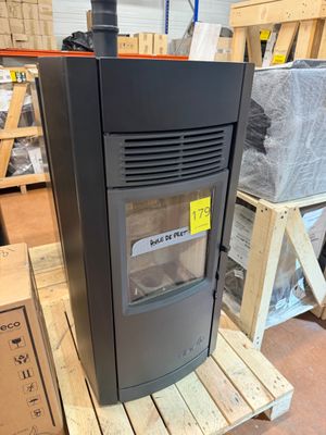 an image of a wood burning stove sitting on a pallet in a warehouse