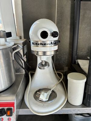 a kitchen aid mixer sitting on a shelf in a kitchen
