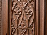 carved wood paneled door in a large room with a clock on the wall