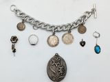 un assortiment d'objets en argent et de bijoux en argent, comprenant une pièce de monnaie, un collier et un bracelet