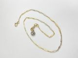 a close up of a necklace and a chain on a white surface