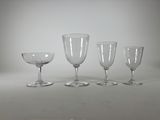 quatre verres à vin vides posés sur une table blanche