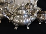 a lot of silver teapots on a black table