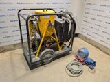 a yellow machine sitting on top of a cement floor next to a wall