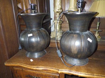 deux vases posés sur une table sur laquelle se trouve une lampe