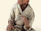une figurine représentant un homme assis par terre