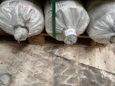 de nombreux rouleaux de plastique emballés dans des sacs en plastique, posés sur une palette