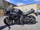 a black motorcycle parked in a parking lot next to a building