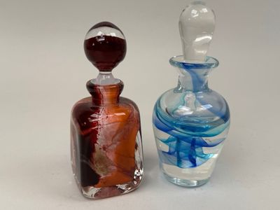 deux bouteilles en verre posées l'une à côté de l'autre