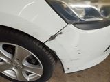 a white car that has a dent in the front of it