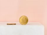 a gold coin sitting on top of a white box