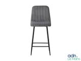 un tabouret de bar gris avec une structure en métal noir et une assise rembourrée grise