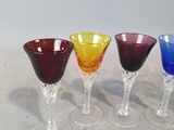 four different colored wine glasses sitting on a table