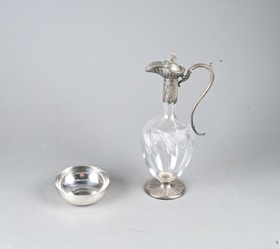 une assiette en argent et un pichet en verre posés sur une table