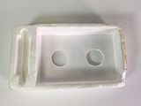 a white tray with two holes in it on a table