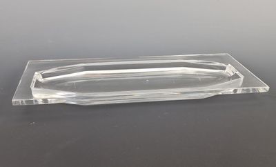 a clear glass tray with a curved edge on a table