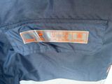 the back of a blue jacket with an orange and white label on it