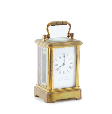 a small gold clock with a handle on a white background