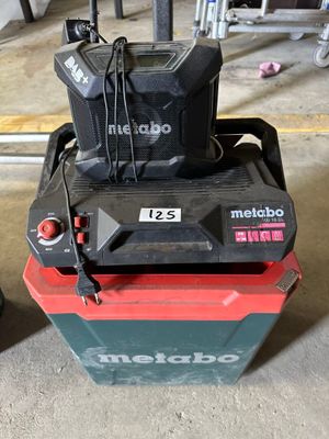 un chariot élévateur rouge et noir sur lequel est posé un sac noir