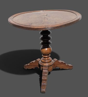 une vieille table en bois avec un plateau rond et un piètement en bois