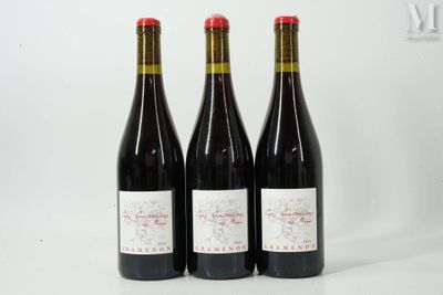 trois bouteilles de vin rouge sont posées sur une surface blanche