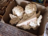 deux statues d'anges dans une boîte en carton posée sur une table