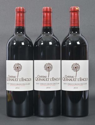 three bottles of red wine sitting on top of a table
