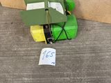 a green toy plane sitting on the ground next to a person ' s feet