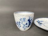 pair of blue and white porcelain cups and saucers on a table