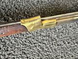 a close up of a rifle with a wooden handle on a carpet
