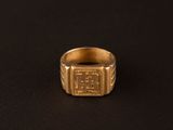 gros plan d'une bague en or sur une surface noire