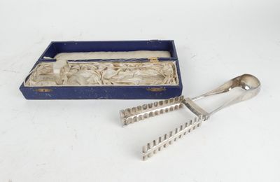 un service d'argenterie ancienne dans un coffret bleu posé sur une surface blanche