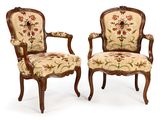 paire de fauteuils de style Louis XV aux accoudoirs rembourrés d'un motif floral